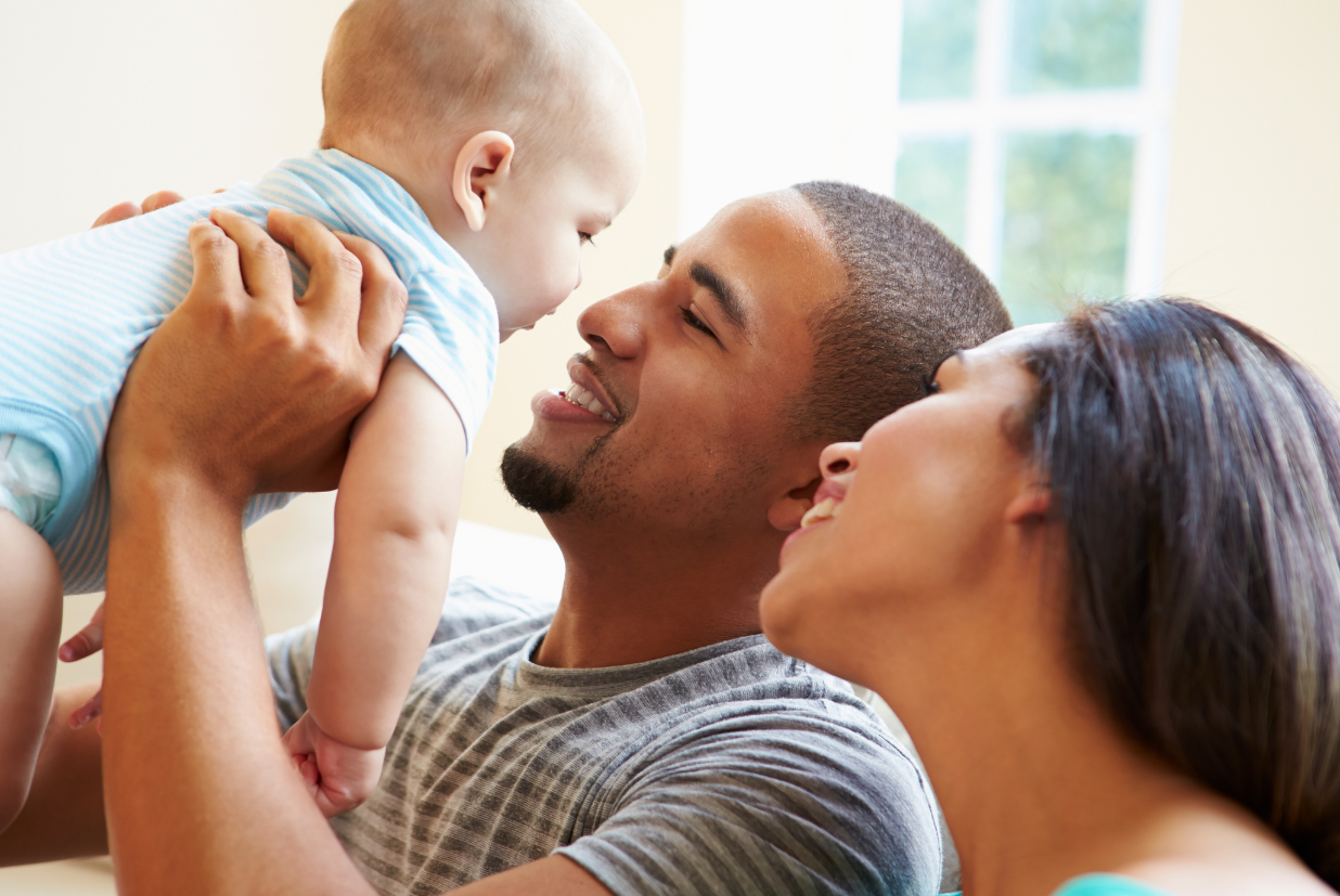 man looking at a baby while holding him up
