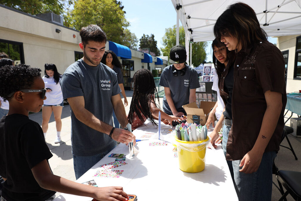 Volunteers building air rockets with kids at Help Group Resource Fair 2026