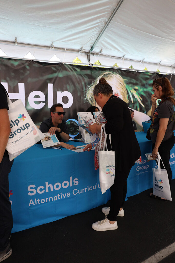 Attendees interacting with Help Group booth at Resource Fair 2026