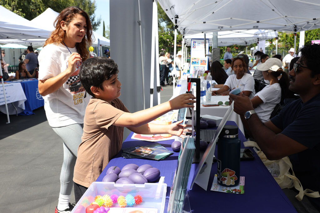 Kid interacting with a vendor booth at Resource Fair 2026