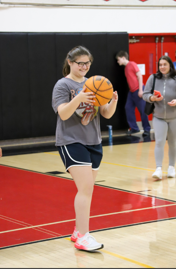 Young girl playing basketball in school gym