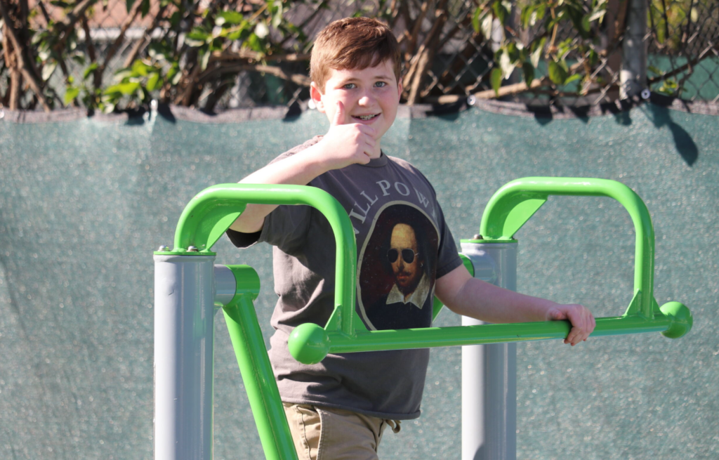Consistent Play - boy exercising on school equipment on school playground